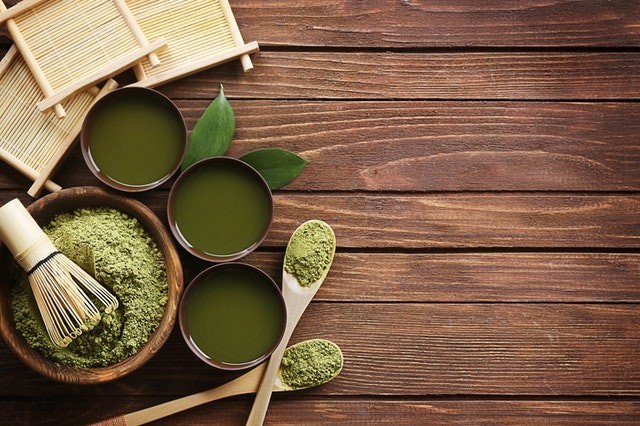 bowls of green powder against wood background